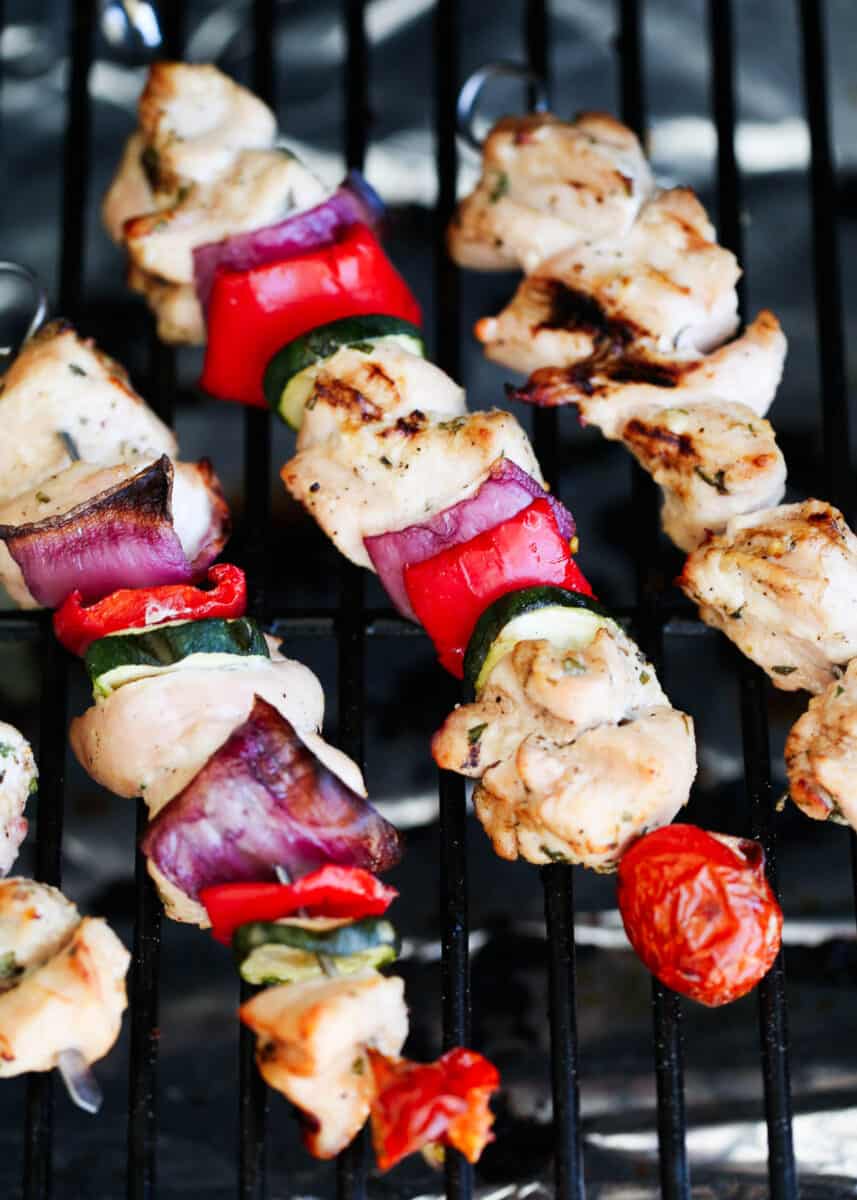 Cooking Greek chicken kabobs with vegetables on the grill.