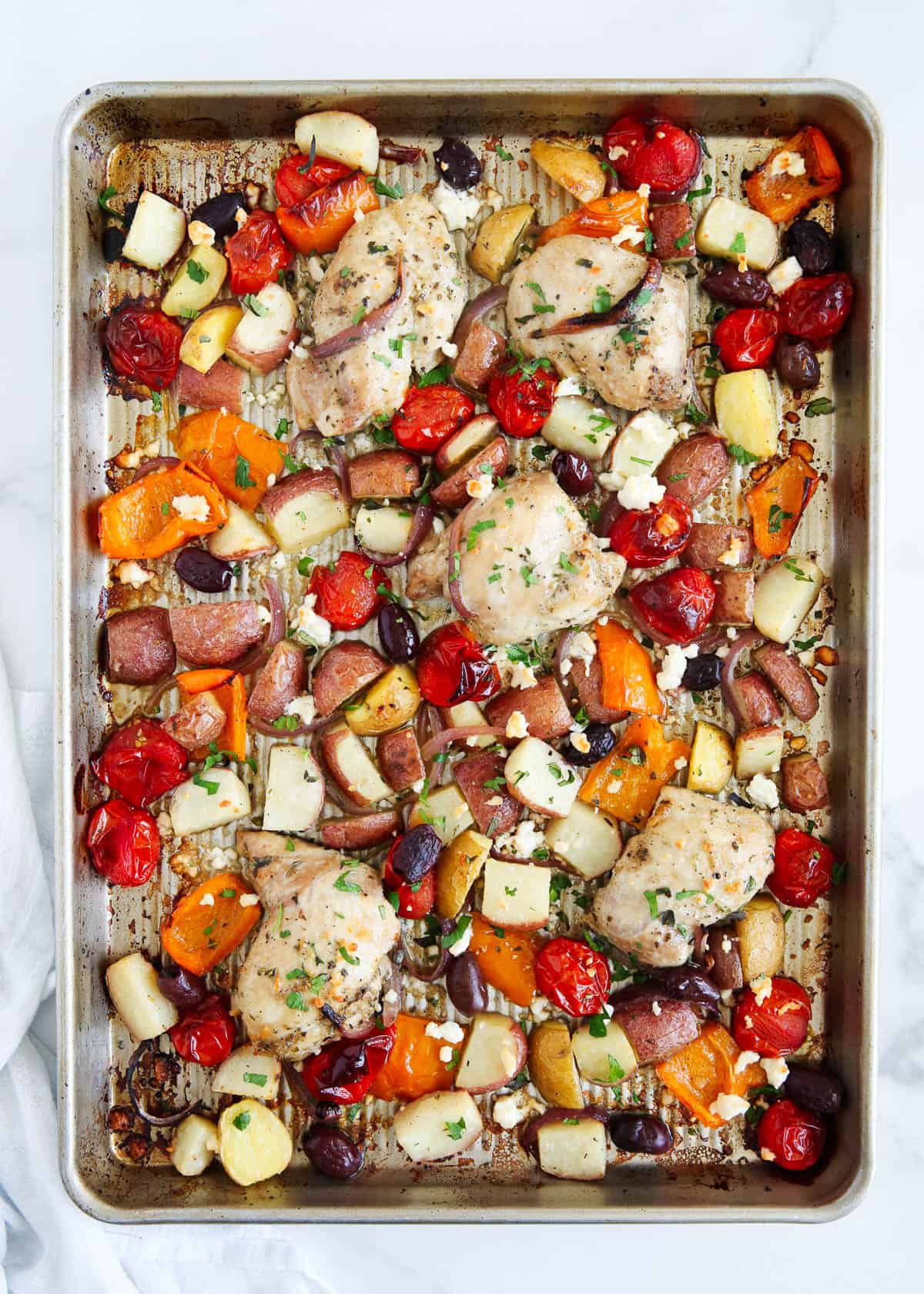 greek chicken and vegetables cooked on sheet pan