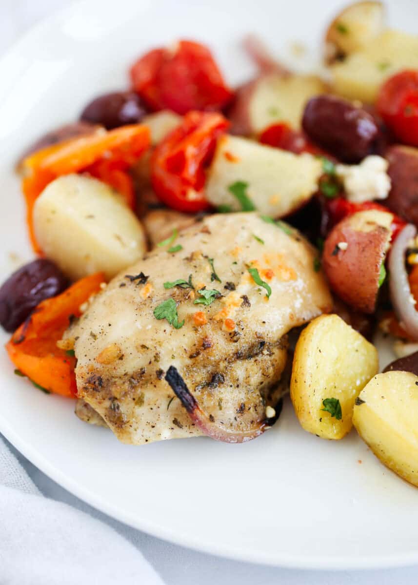 Greek chicken and vegetables on plate.