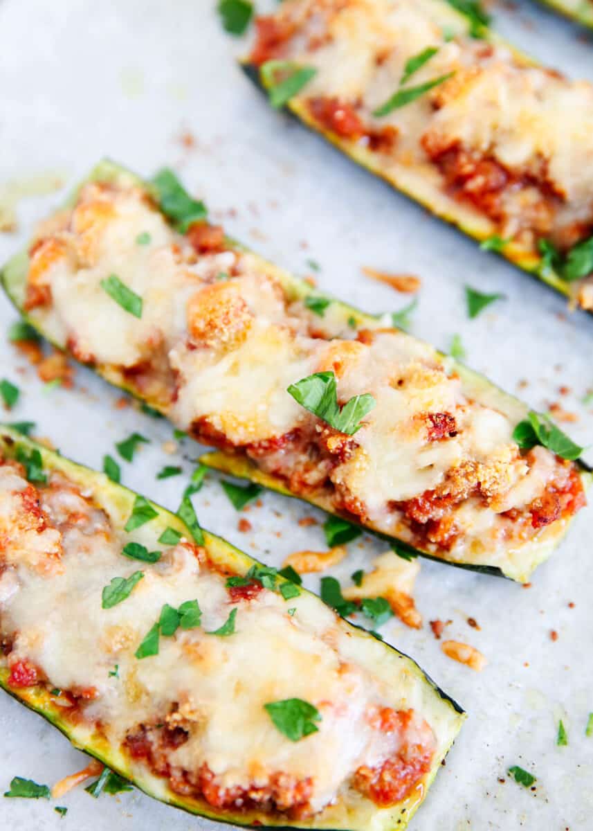 Zucchini boat with cheese and parsley on top.