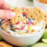 Dipping animal cracker into funfetti dip.