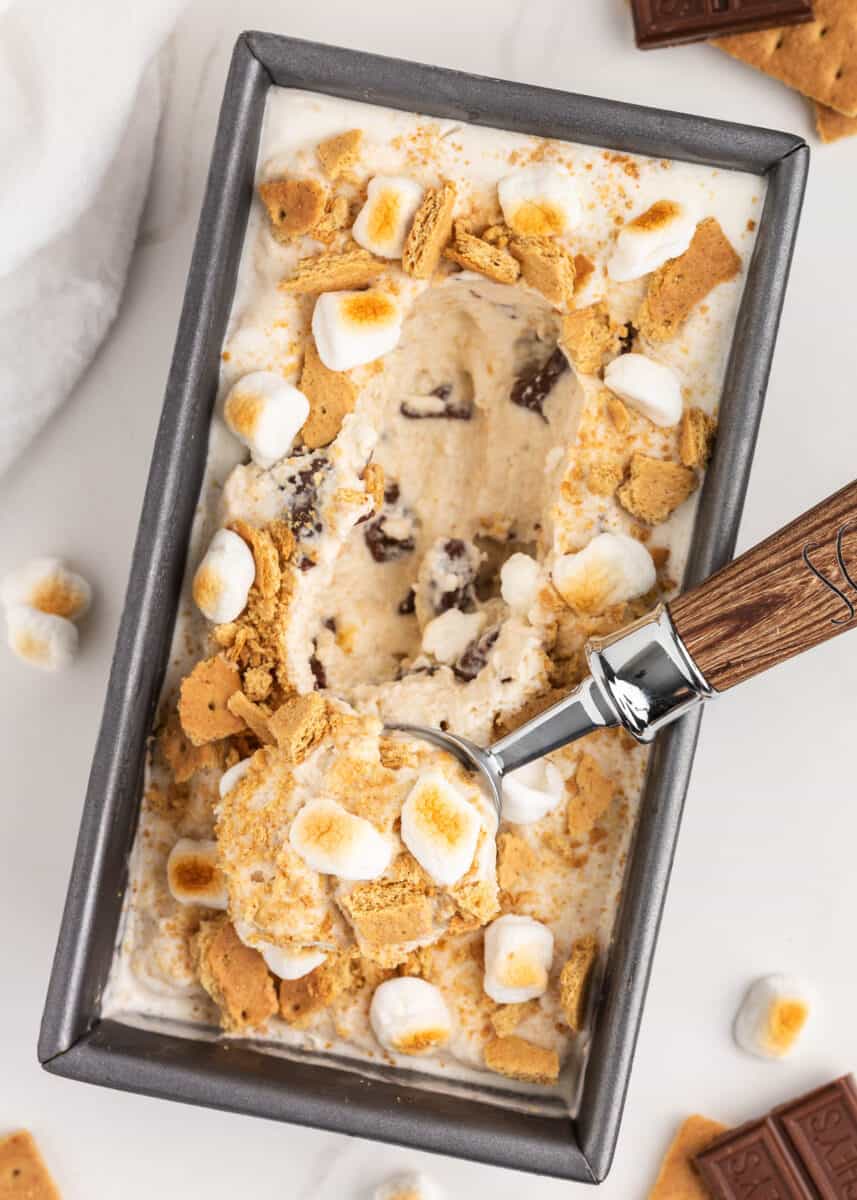 Scooping out s'mores ice cream from pan.
