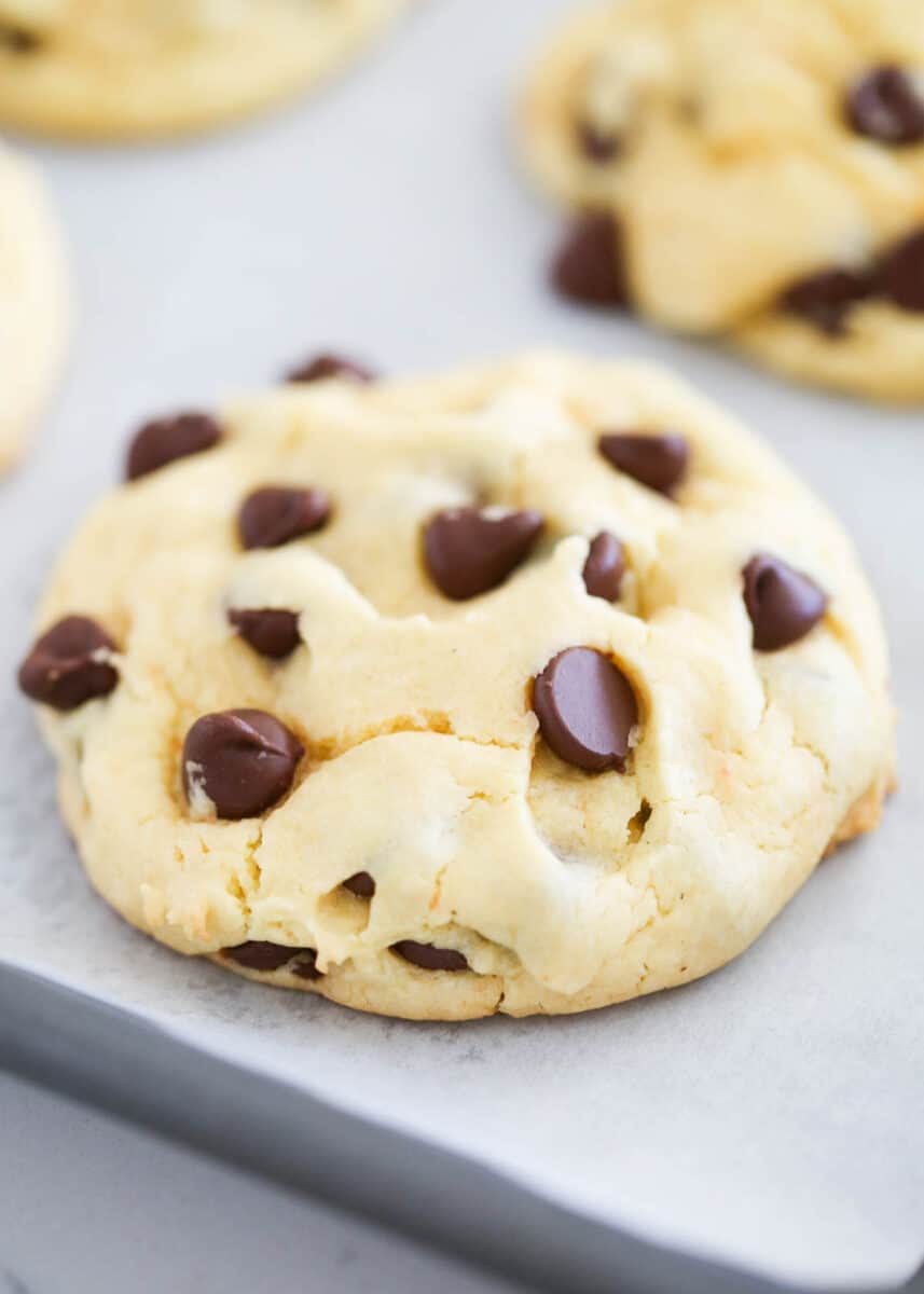Cake mix chocolate chip cookies are chewy and delicious, and take quick and easy cookie recipes to another level using just a boxed mix, oil, eggs, and loads of chocolate chips! Cake mix chocolate chip cookie on parchment paper.