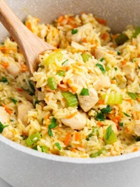 Spoonful of chicken and rice in a pot.