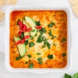 Chicken enchilada dip in white baking dish.