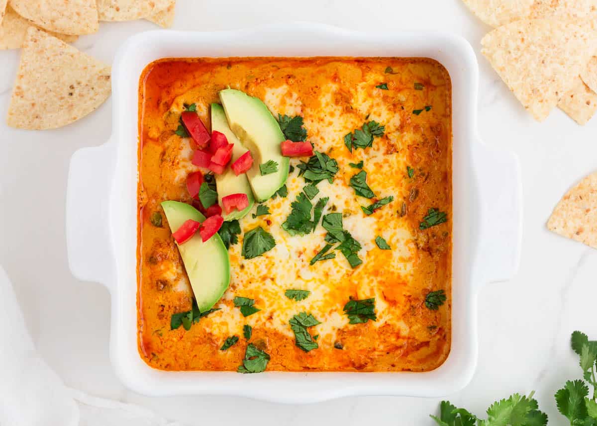 Chicken enchilada dip in white baking dish.