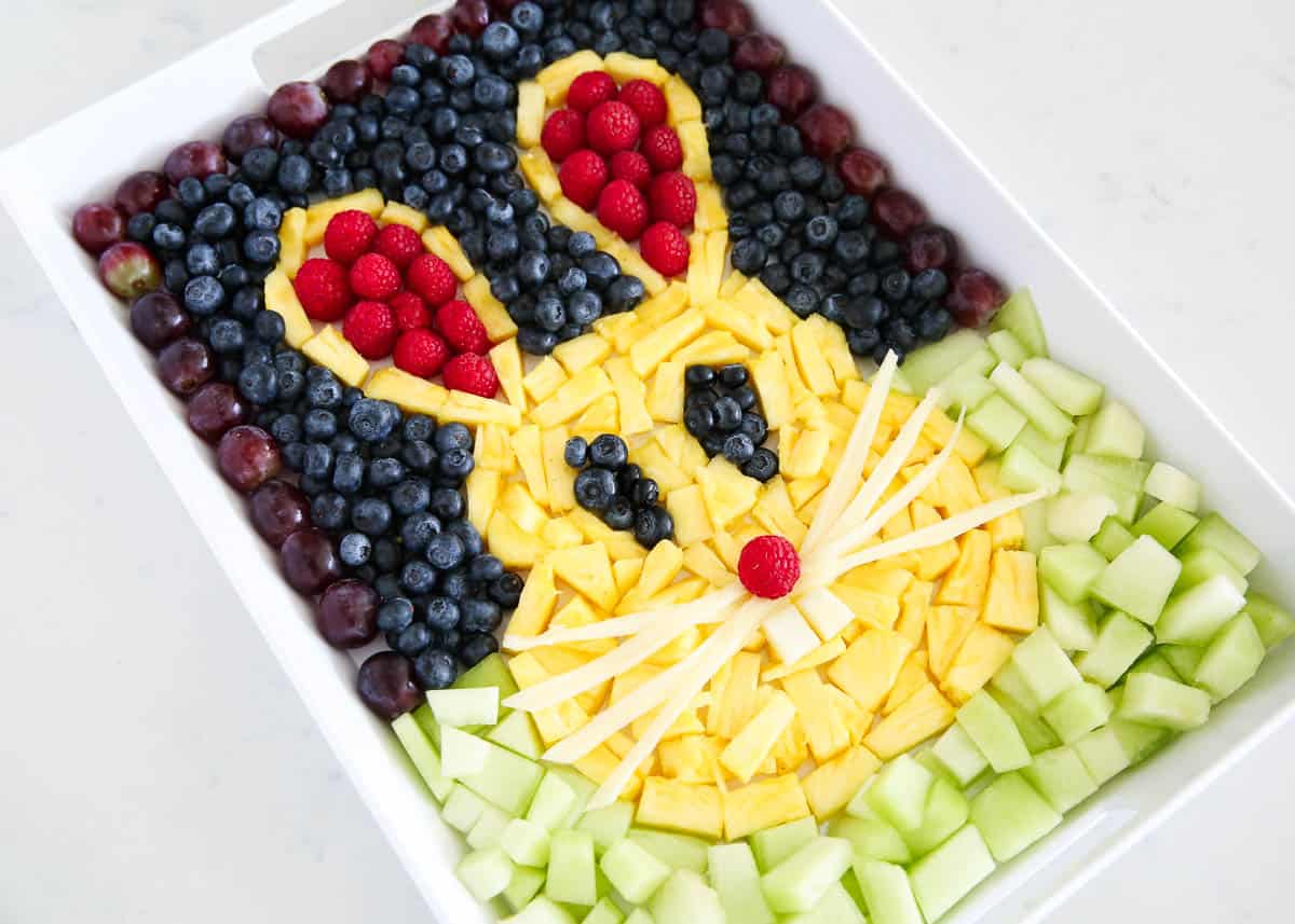Easter fruit tray with berries, pineapple, and honeydew in the shape of a bunny.