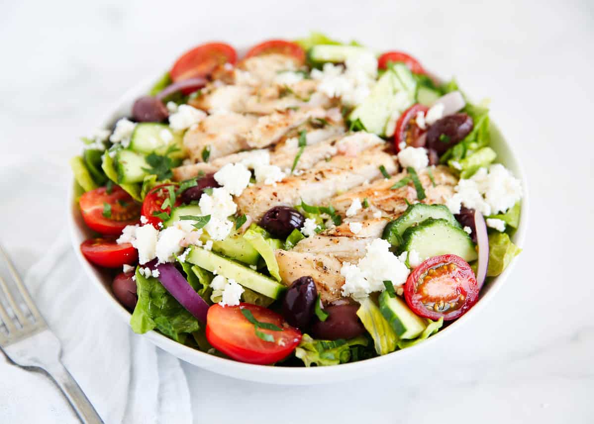 Greek chicken salad in a white bowl.