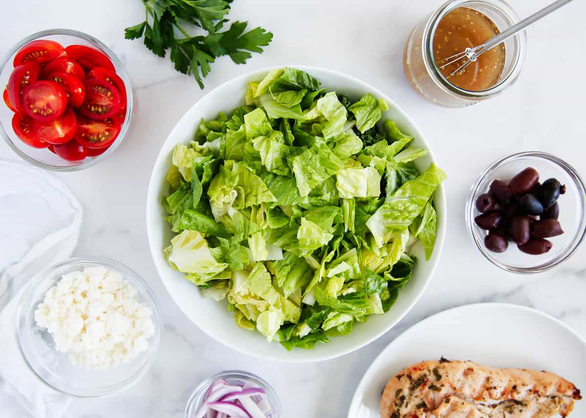 Greek salad ingredients on marble counter.