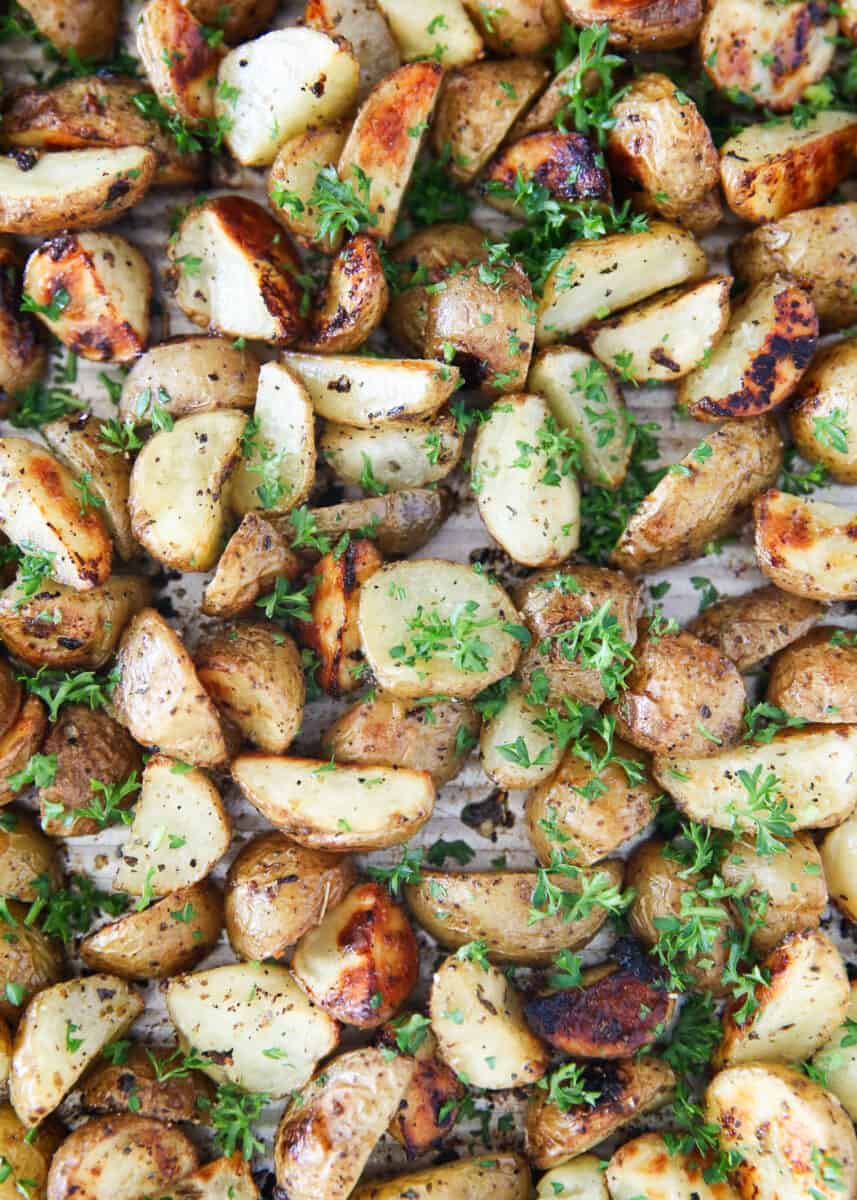 Cooked Greek potatoes on baking sheet with parsley.