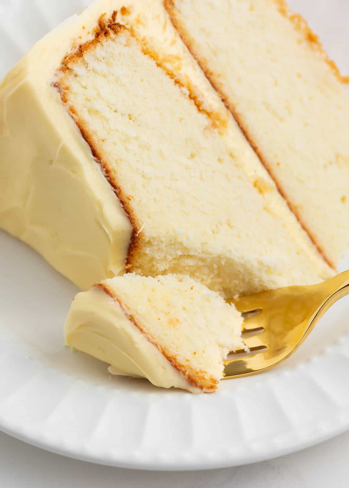 The best vanilla cake is an impressive yet simple one-bowl recipe that makes even a beginner baker feel like a professional! A soft tender cake infused with the heavenly flavor of vanilla that pairs well with any frosting! Slice of vanilla cake with bite taken.