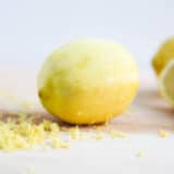 A lemon zested on a cutting board.