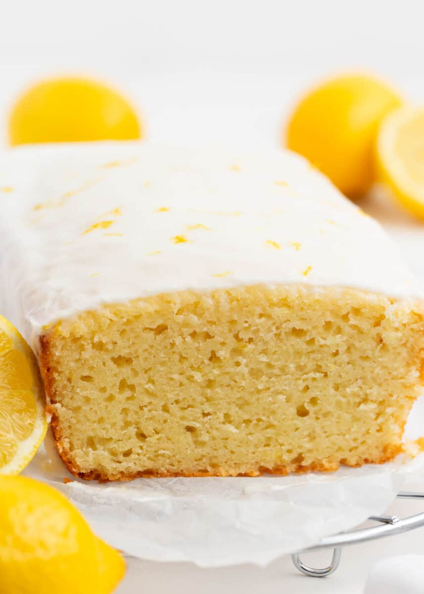 Sliced lemon loaf cake on cooling rack.