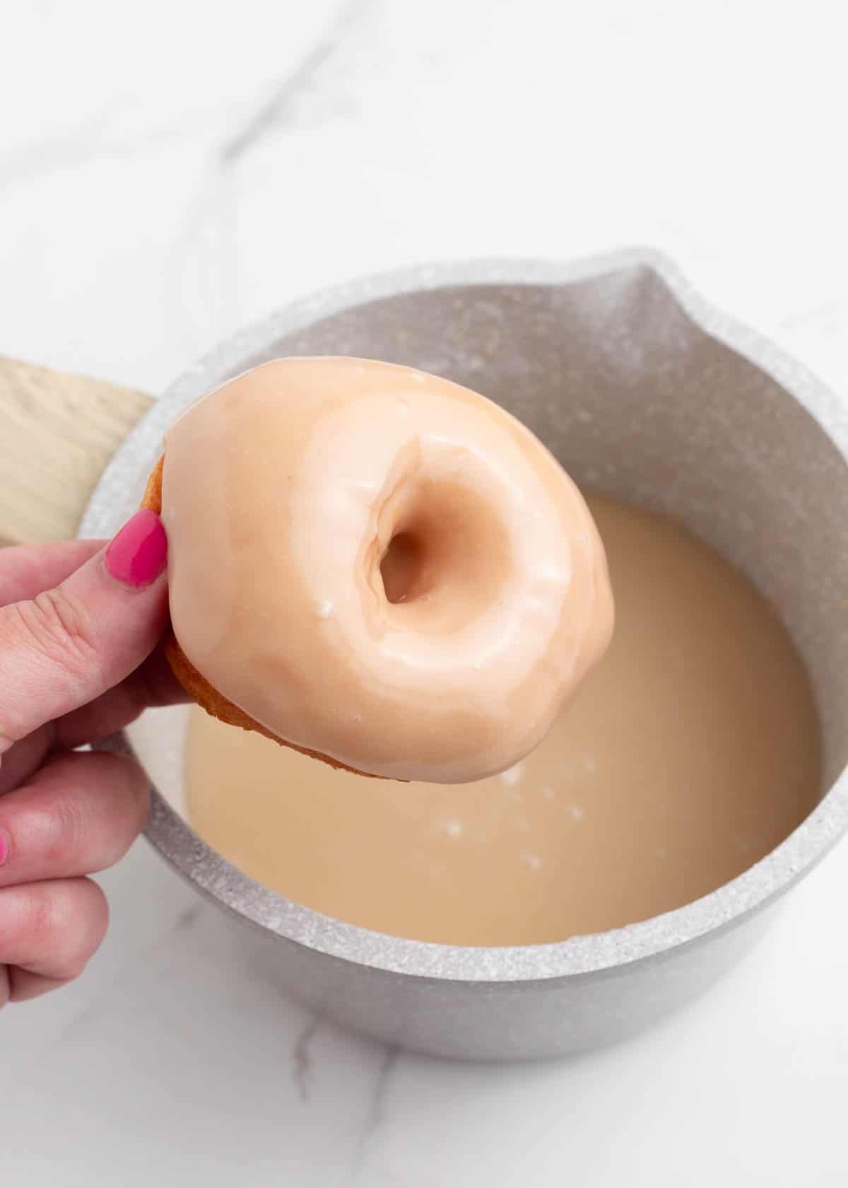 Dipping donut in maple glaze.