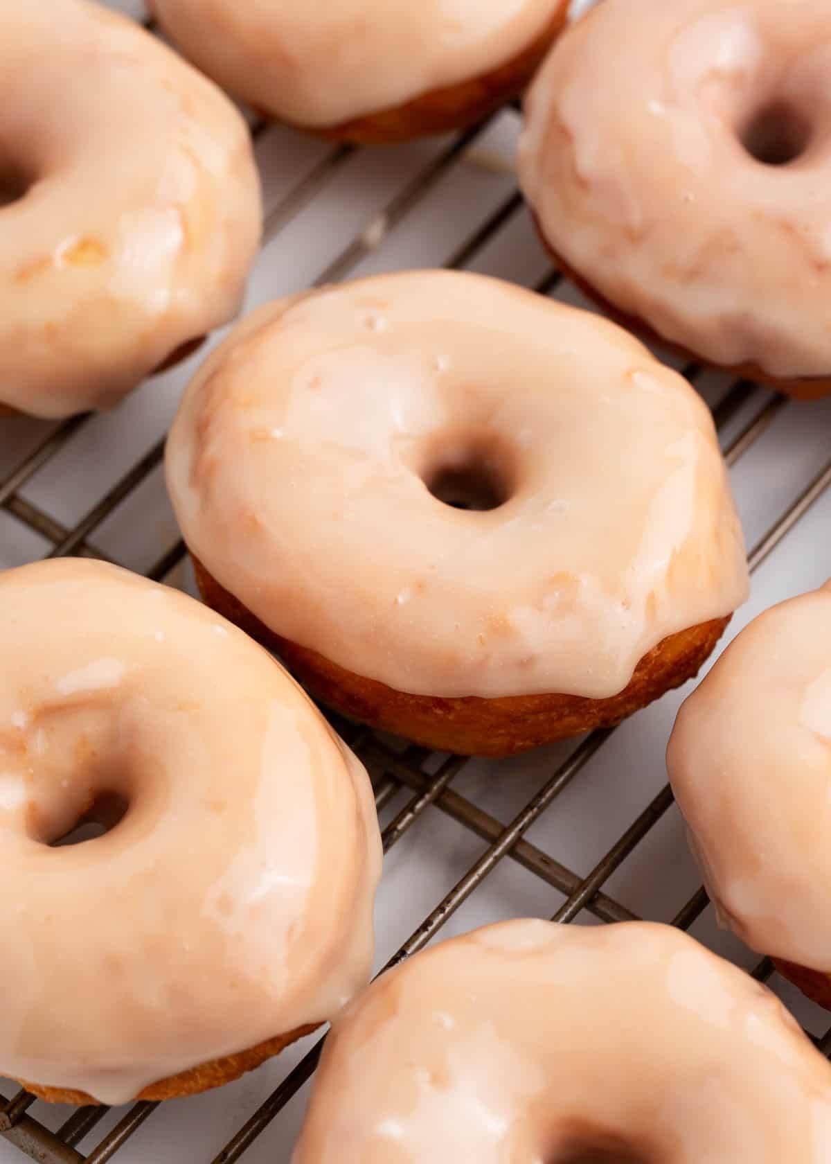 Maple glaze donuts on a cooling rack.