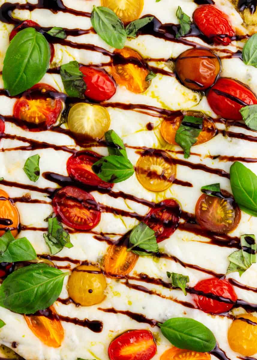 Caprese pizza drizzled with balsamic glaze.