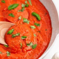 Roasted garlic tomato sauce in skillet with spoon.