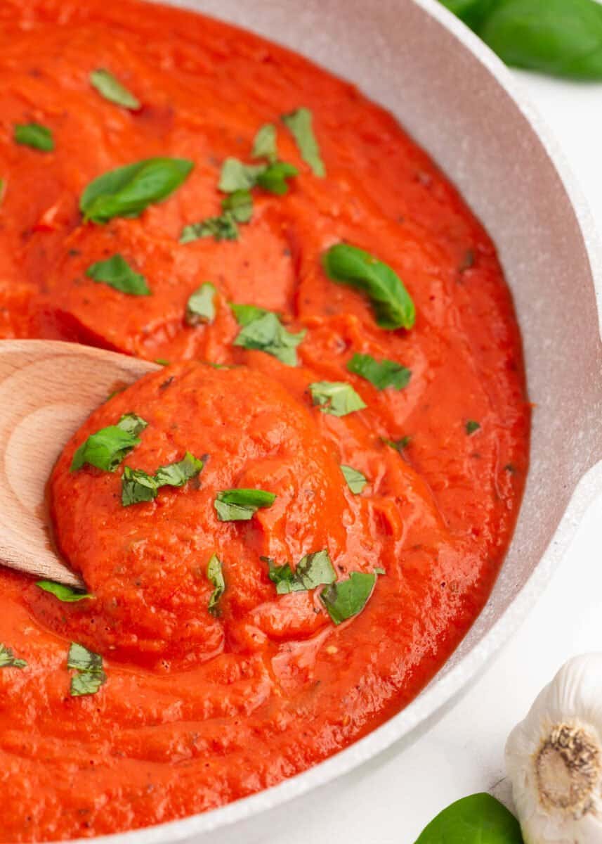 Roasted garlic tomato sauce in skillet with spoon.