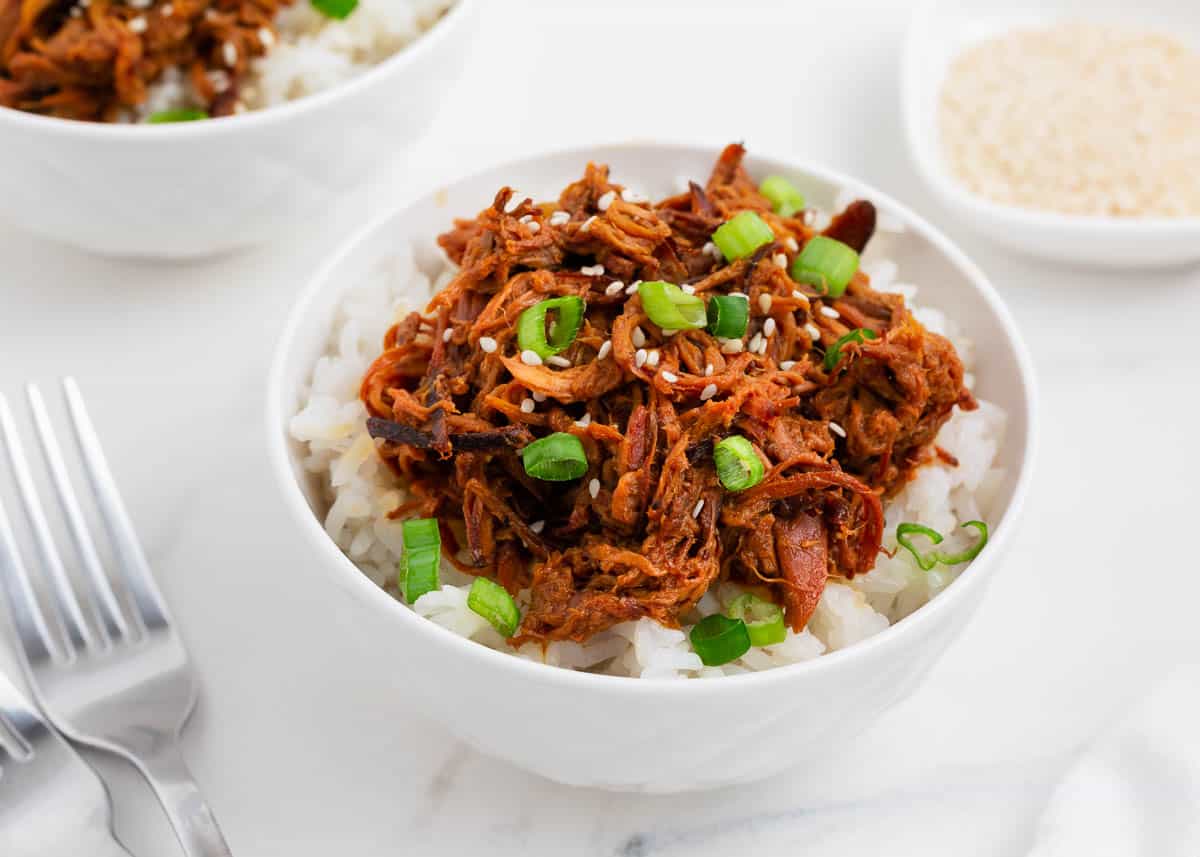 Shredded honey chicken and rice in white bowl.