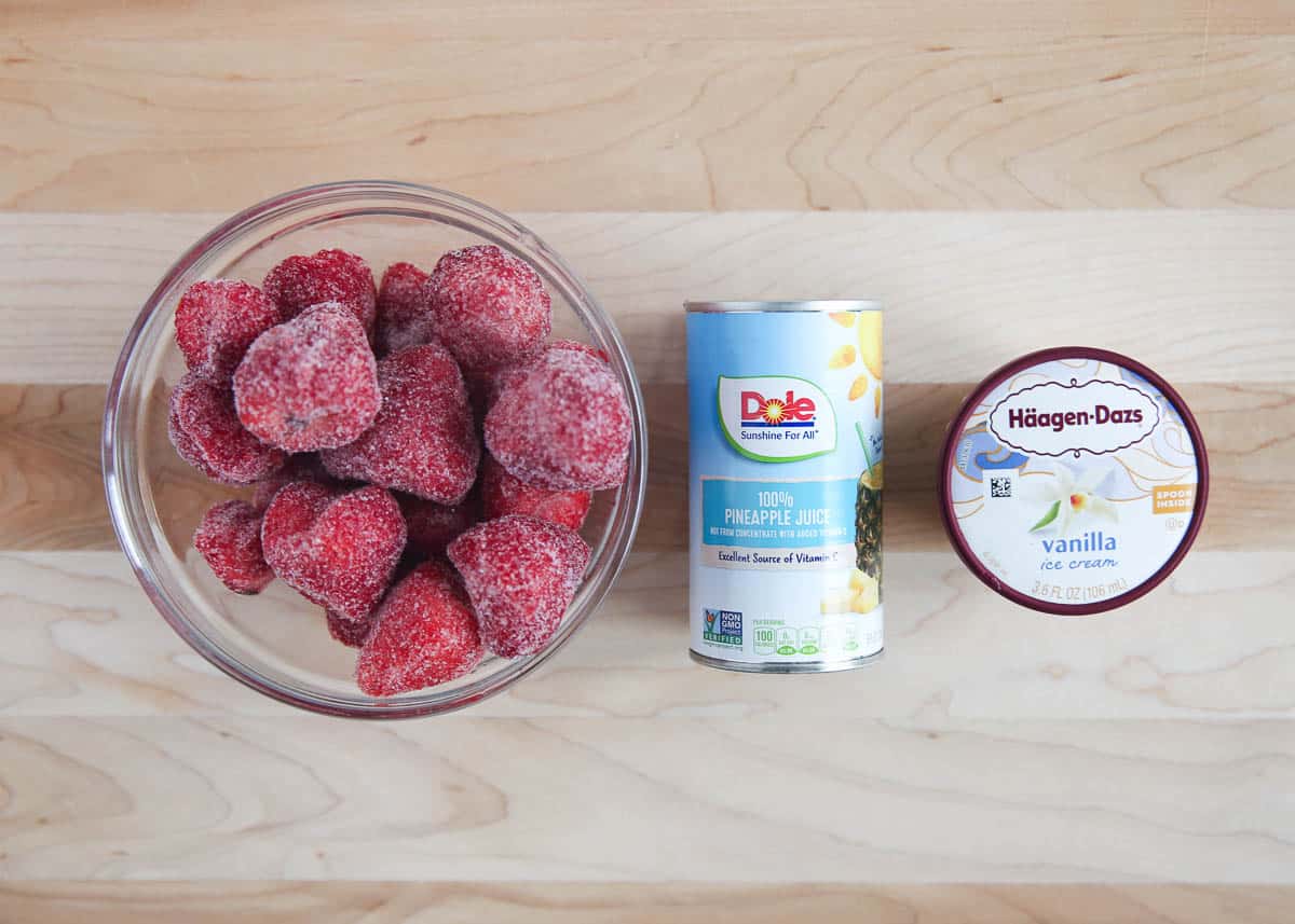 Strawberry dole whip ingredients on wooden board.