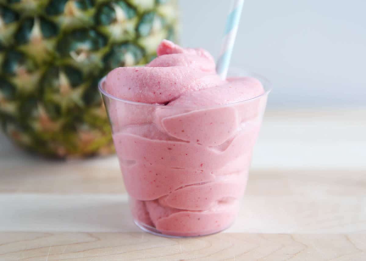 Strawberry Dole Whip in cup with straw. 