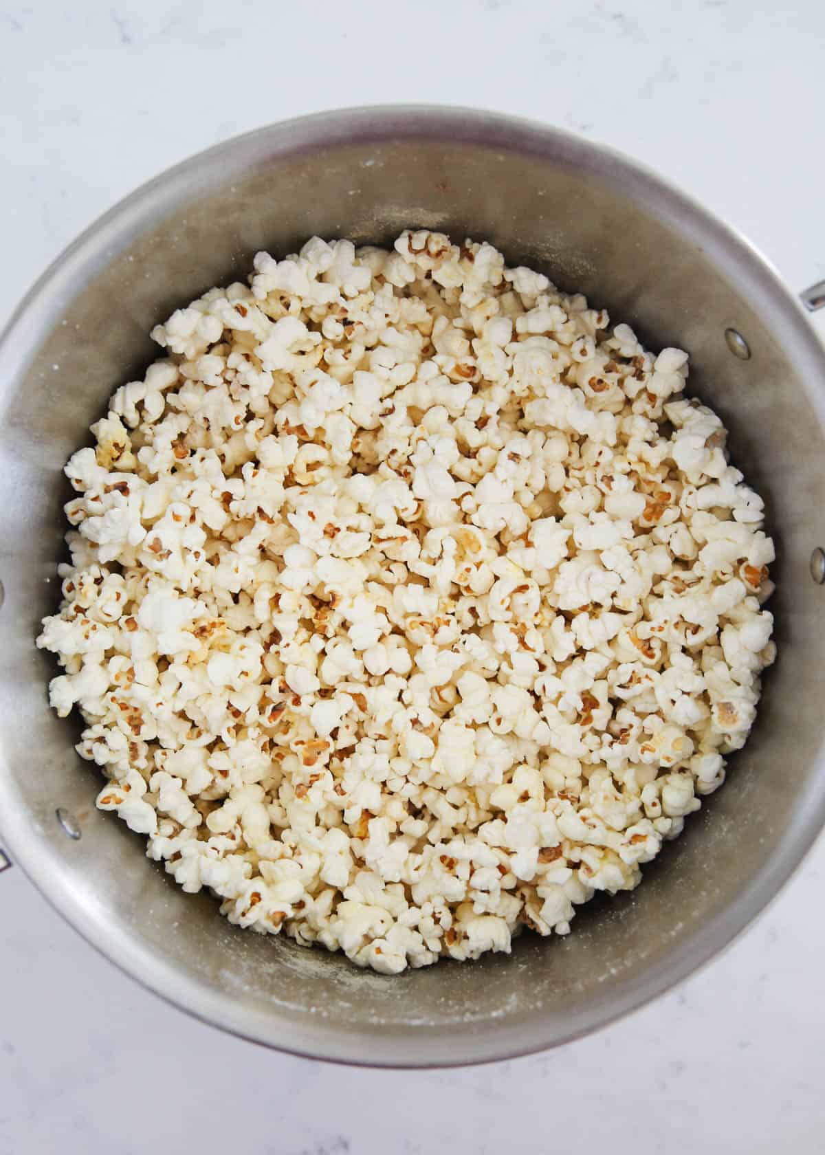 White cheddar popcorn in stainless steel pot.