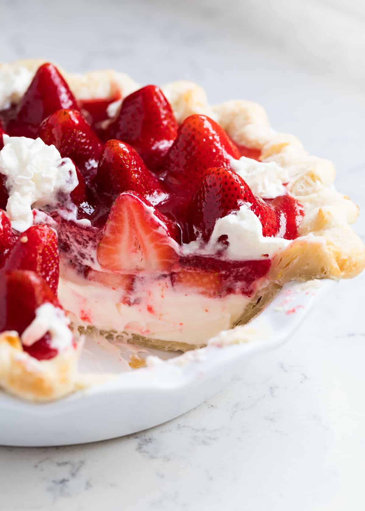 Slice cut out of strawberry cream pie.