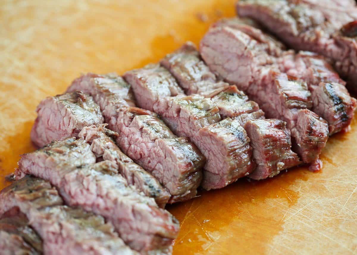 Sliced flank steak on a cutting board.