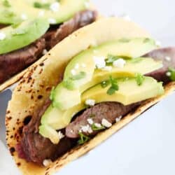 Flank taco with avocado on top.