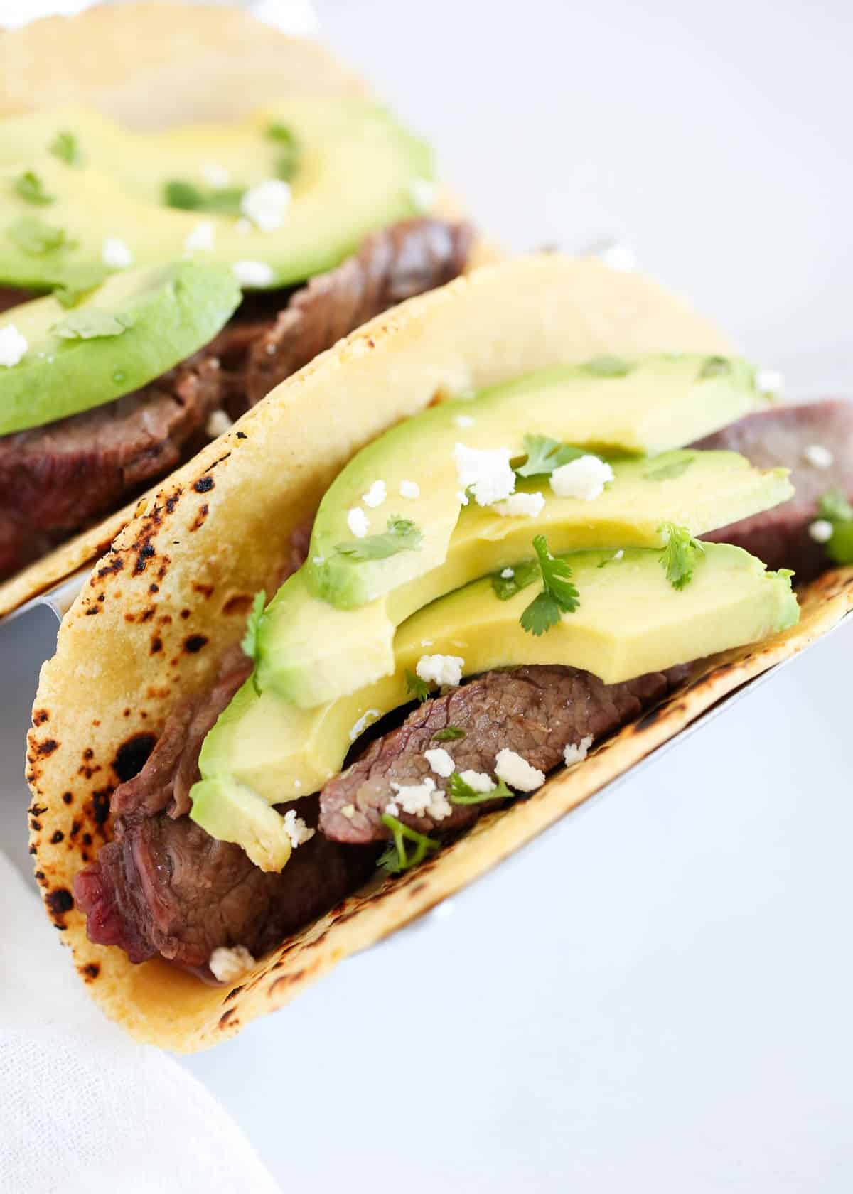 Flank taco with avocado on top.