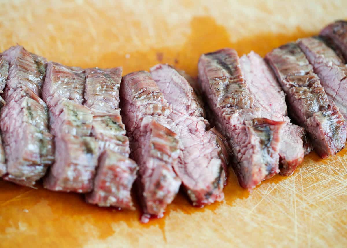 Sliced flank steak on cutting board.