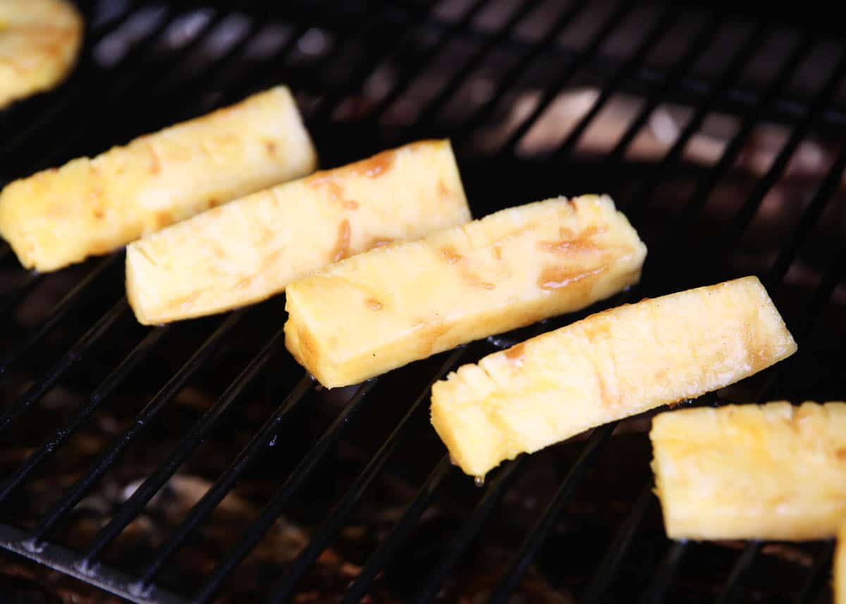 Cooking pineapple slices on grill.