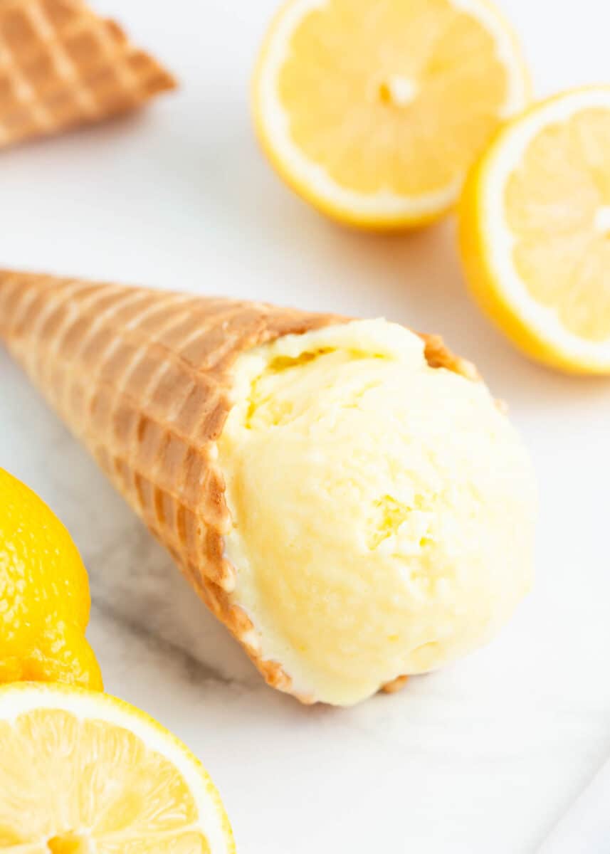 Lemon ice cream cone on marble counter.