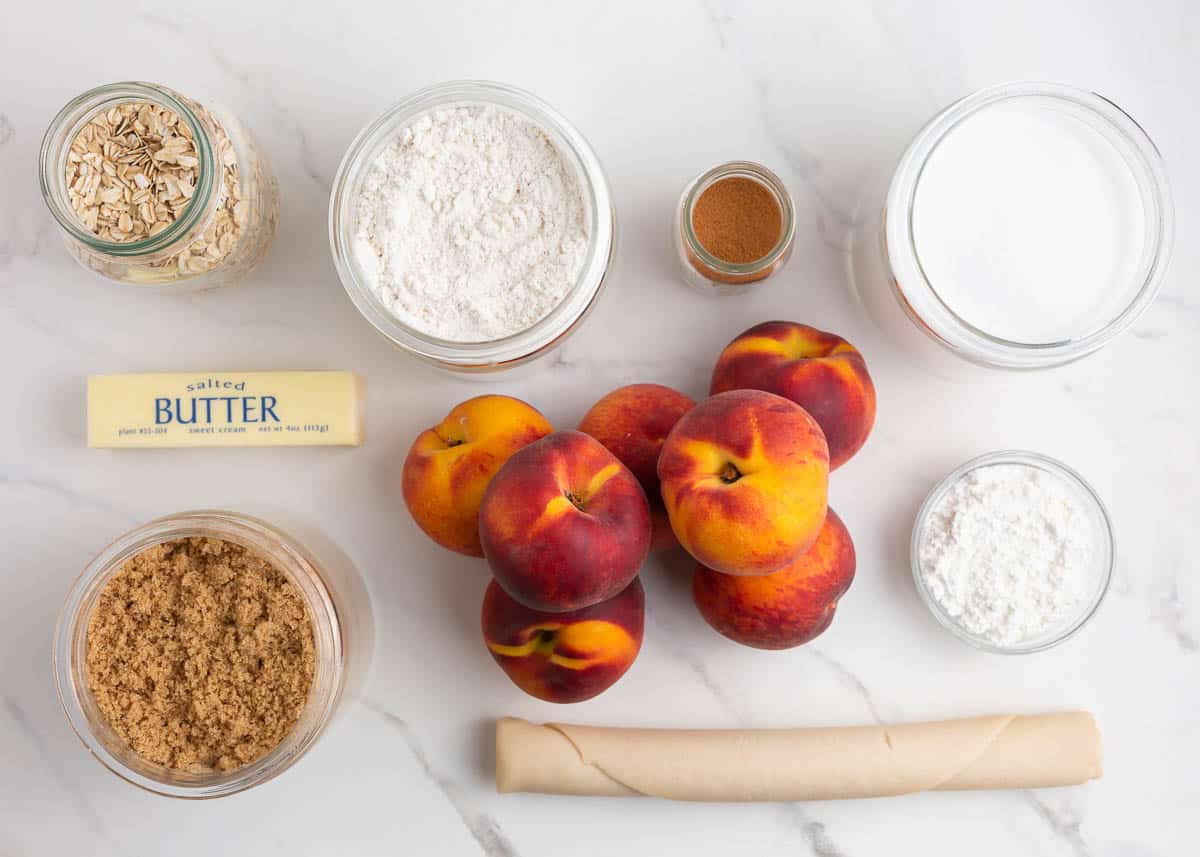 Peach pie ingredients on marble counter.