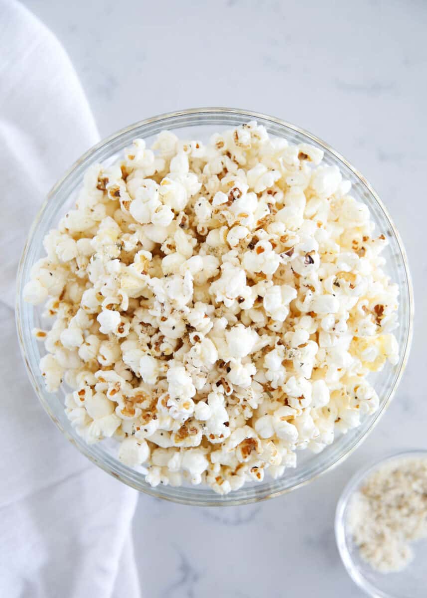 Popcorn and seasoning in a glass bowl.