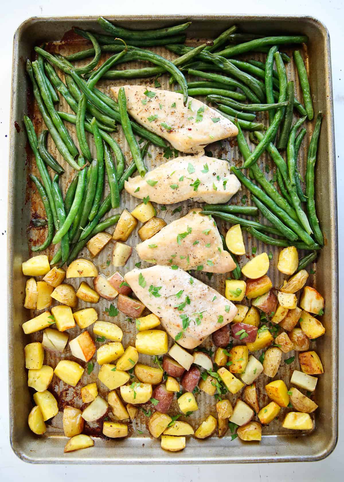 Sheet pan chicken and potatoes on counter.