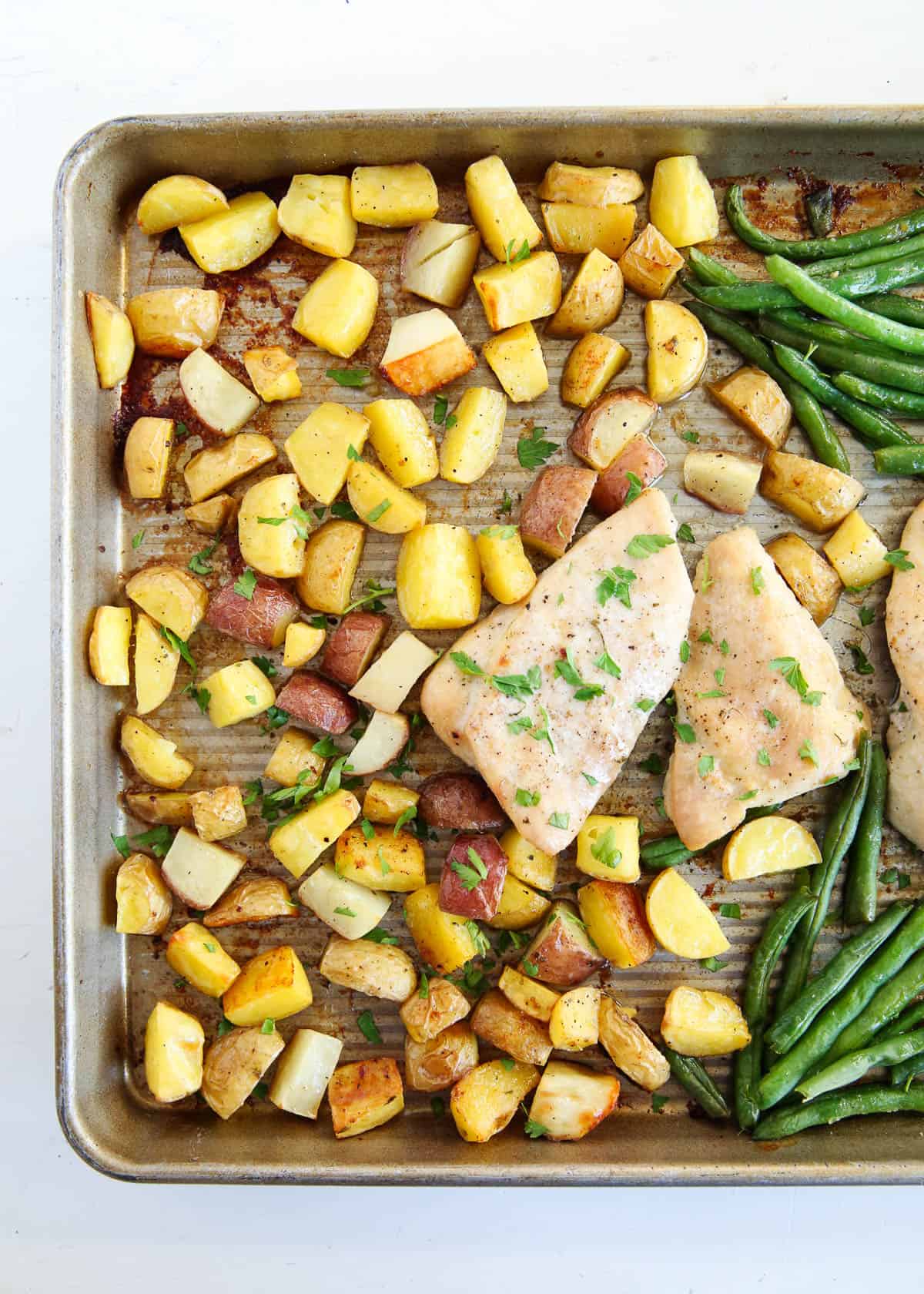 Sheet pan chicken and potatoes on counter.