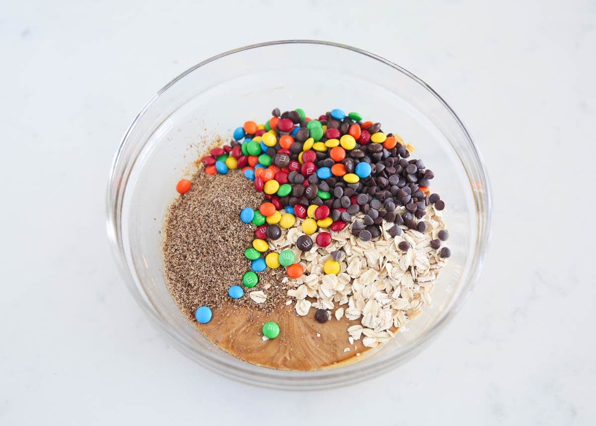 Oats, ground flaxseed, mini M&Ms, and chocolate chips added to the peanut butter base.