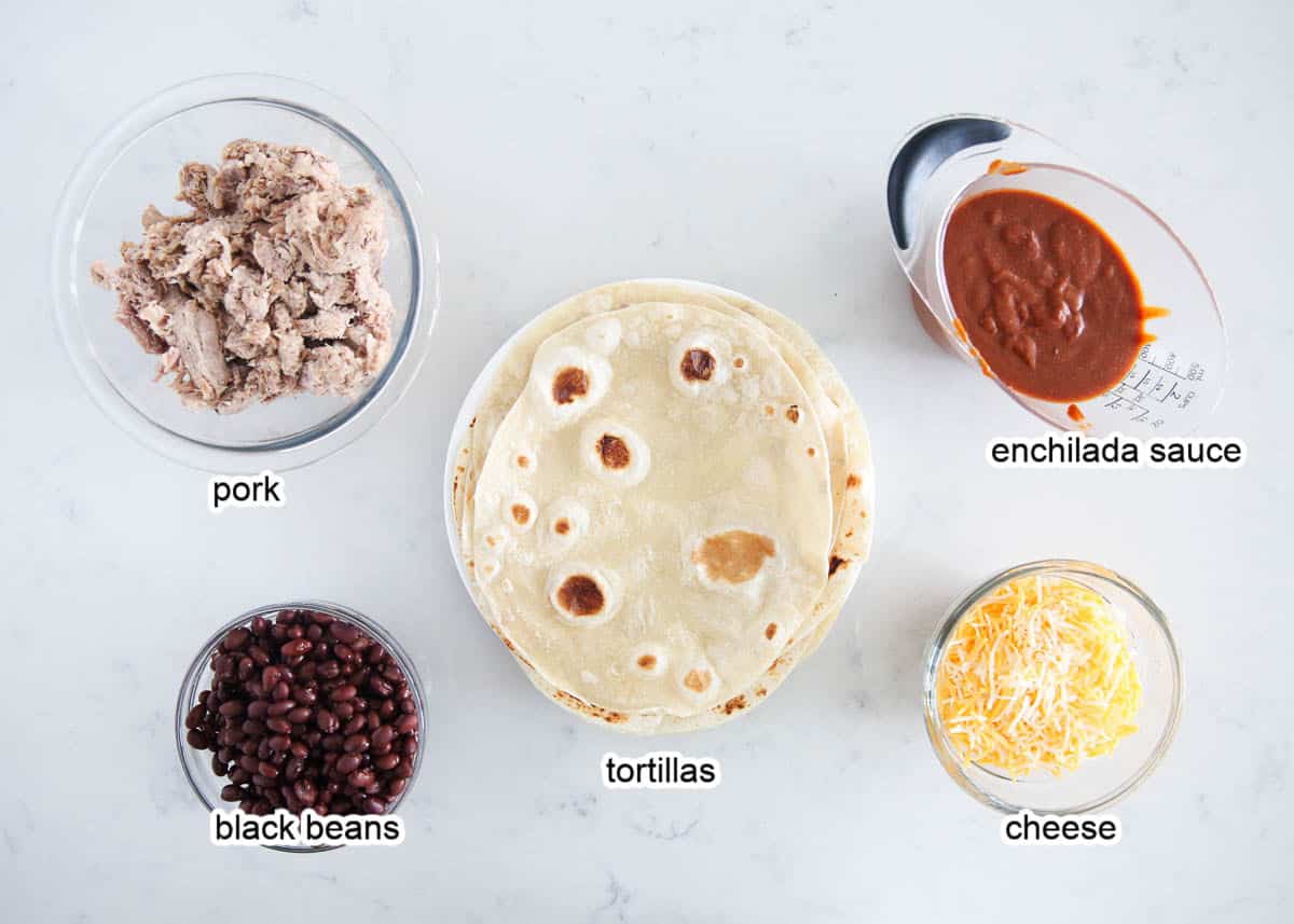 Pork enchilada ingredients on marble counter.