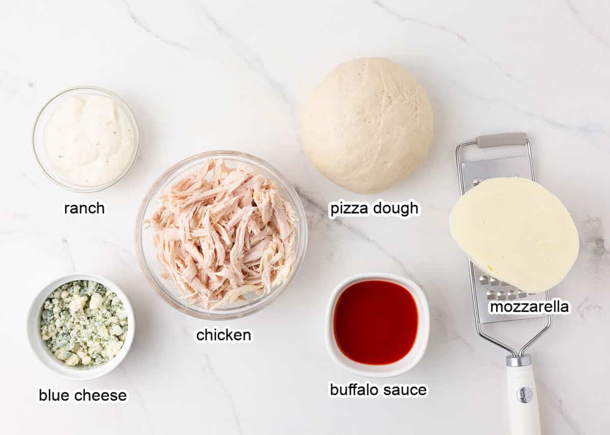 Buffalo chicken pizza ingredients on counter.