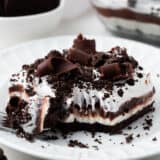 Slice of chocolate lasagna with a fork on a white plate.