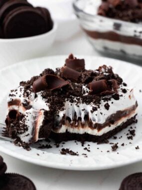 Slice of chocolate lasagna with a fork on a white plate.
