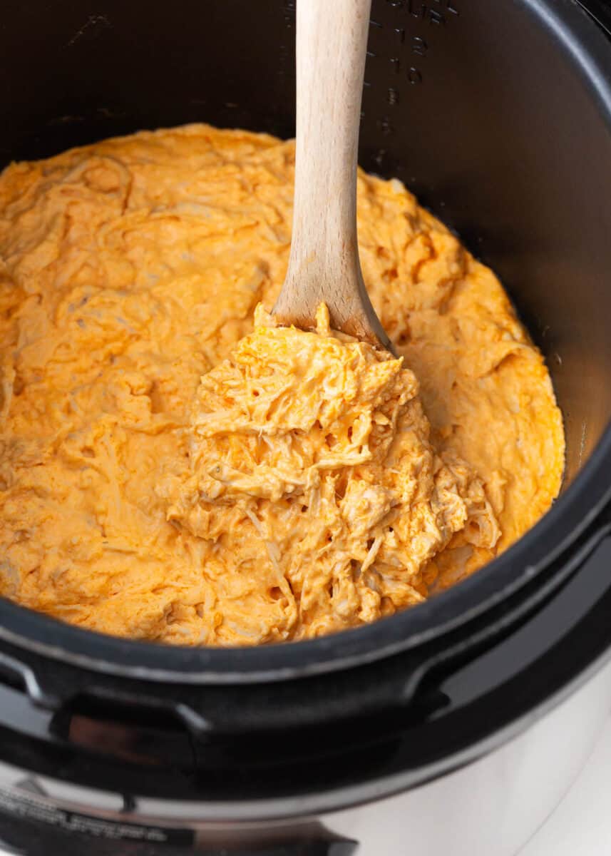 Buffalo chicken dip in instant pot with spoon.
