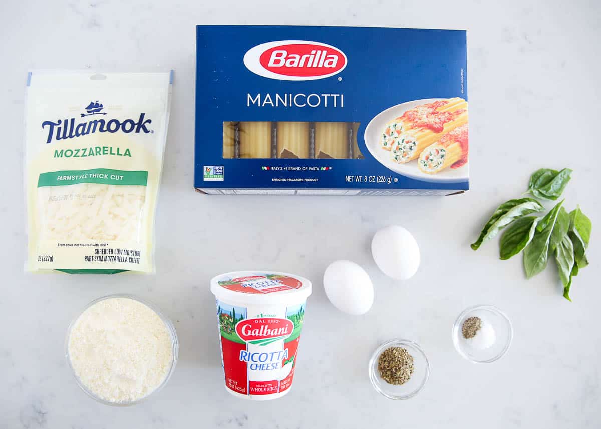 Cheese manicotti ingredients on marble counter.