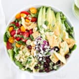 Mexican salad in white bowl on marble countertop.