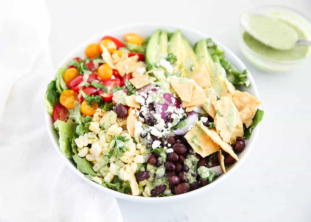 Mexican salad in white bowl on a marble countertop.