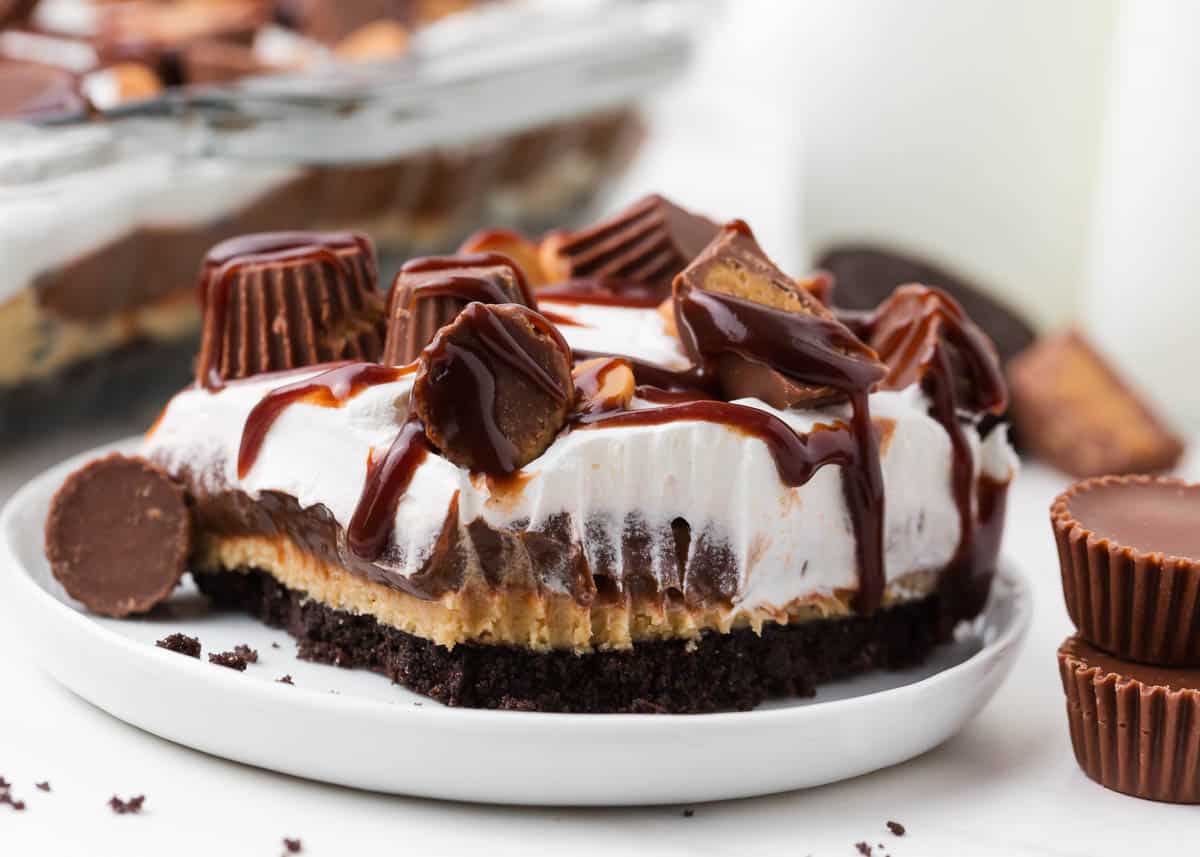 Slice of peanut butter lasagna with chocolate on white plate.