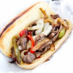 Easy philly cheesesteak with tender ribeye, cheese and peppers and onion on a hoagie bun.