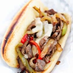 Philly cheesesteak on a hoagie bun in basket.