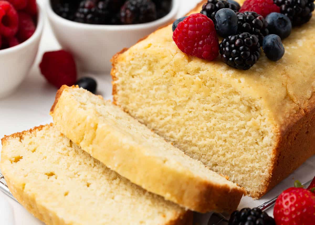 Sliced pound cake with berries on top.
